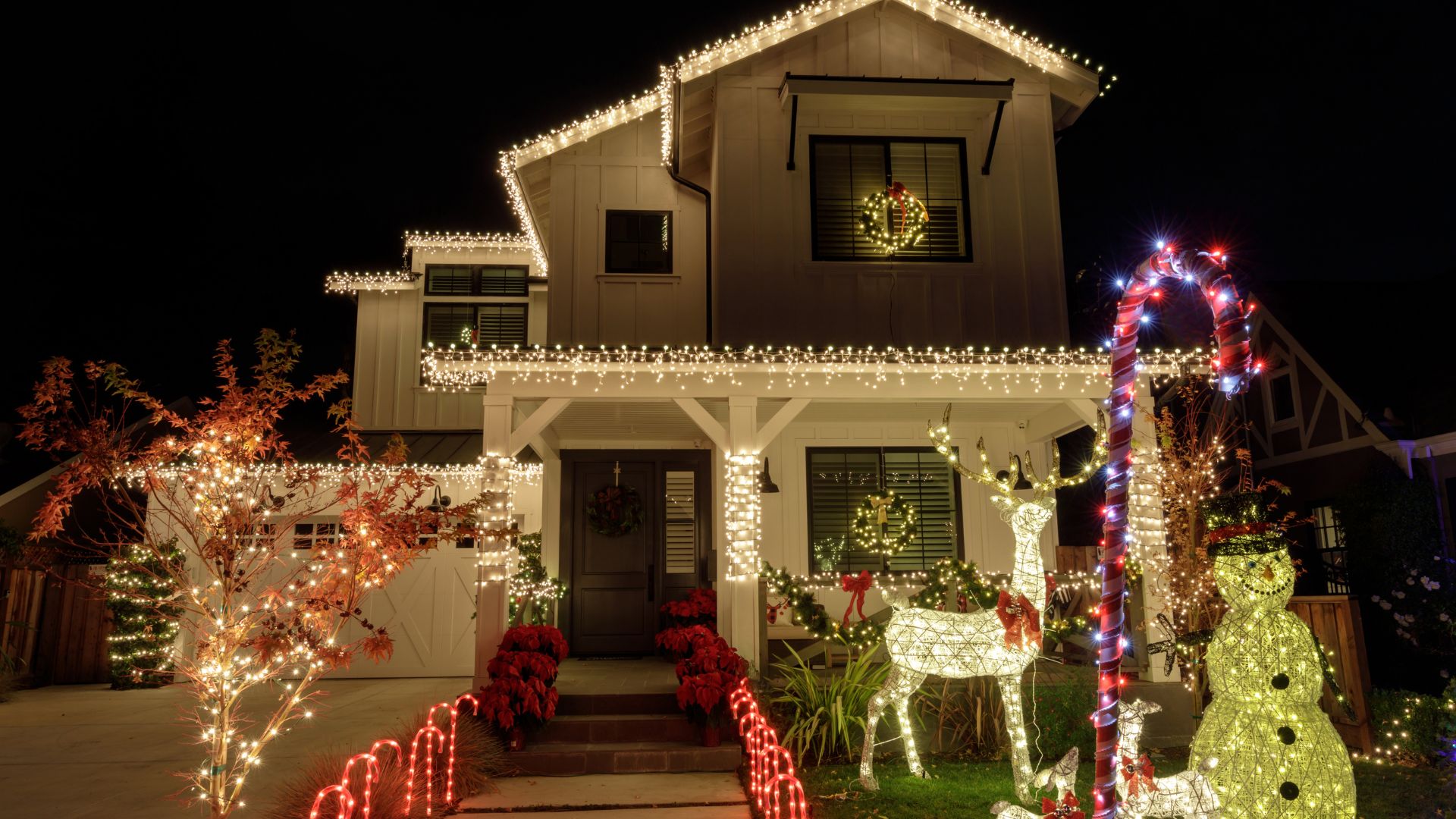 Festive house with Christmas lights, wreaths, and glowing holiday decorations
