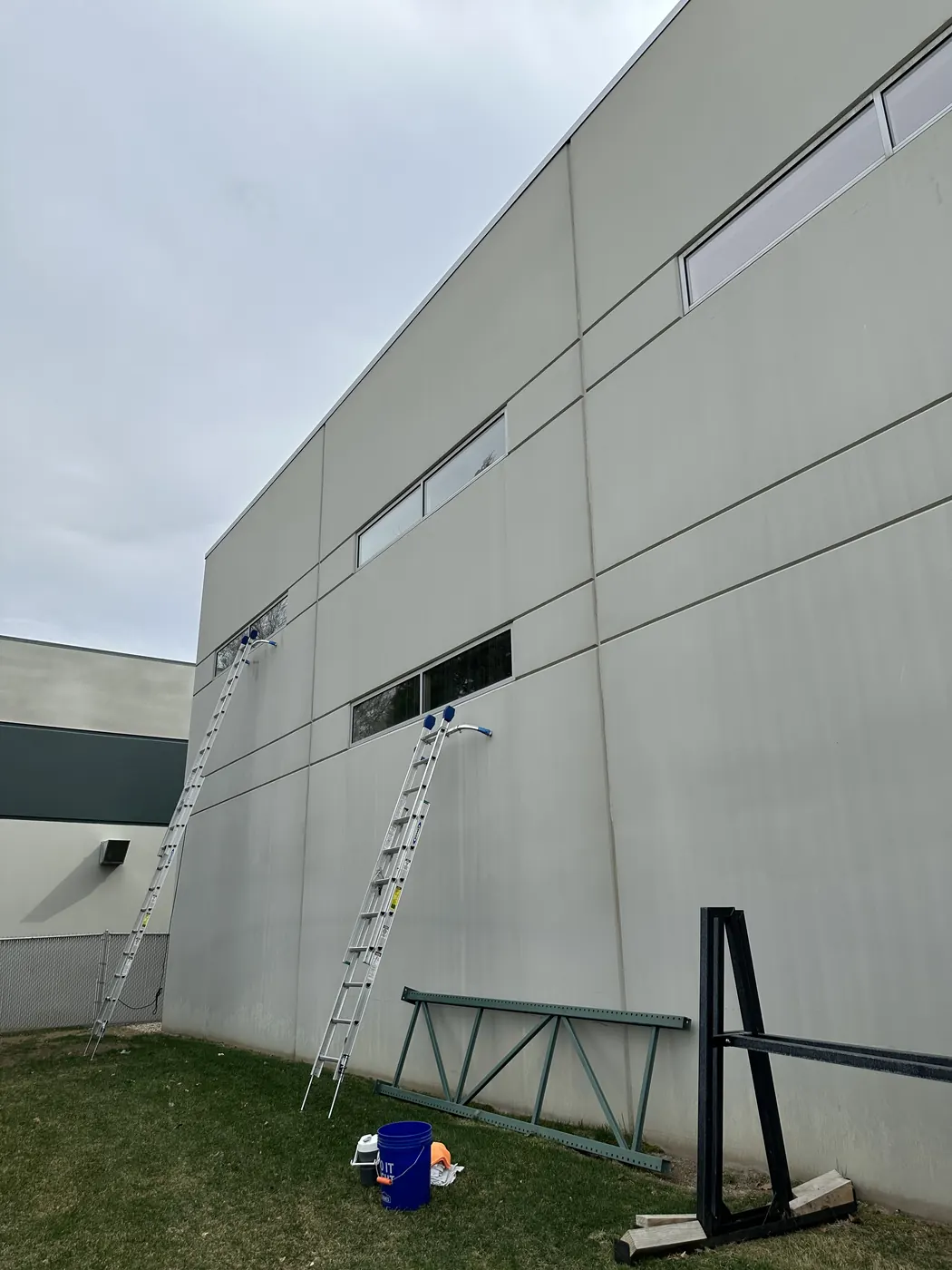 Cleaning the windows of a commercial building from a ladder