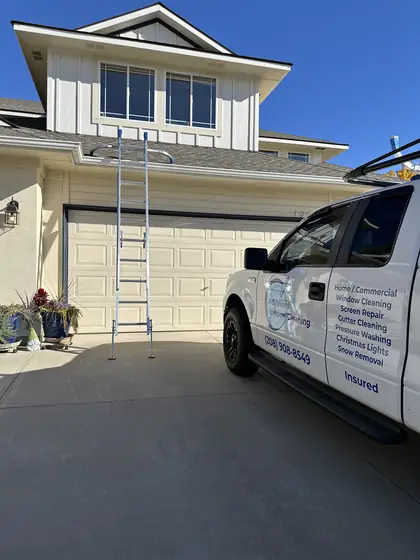Cleaning second-story windows with a ladder