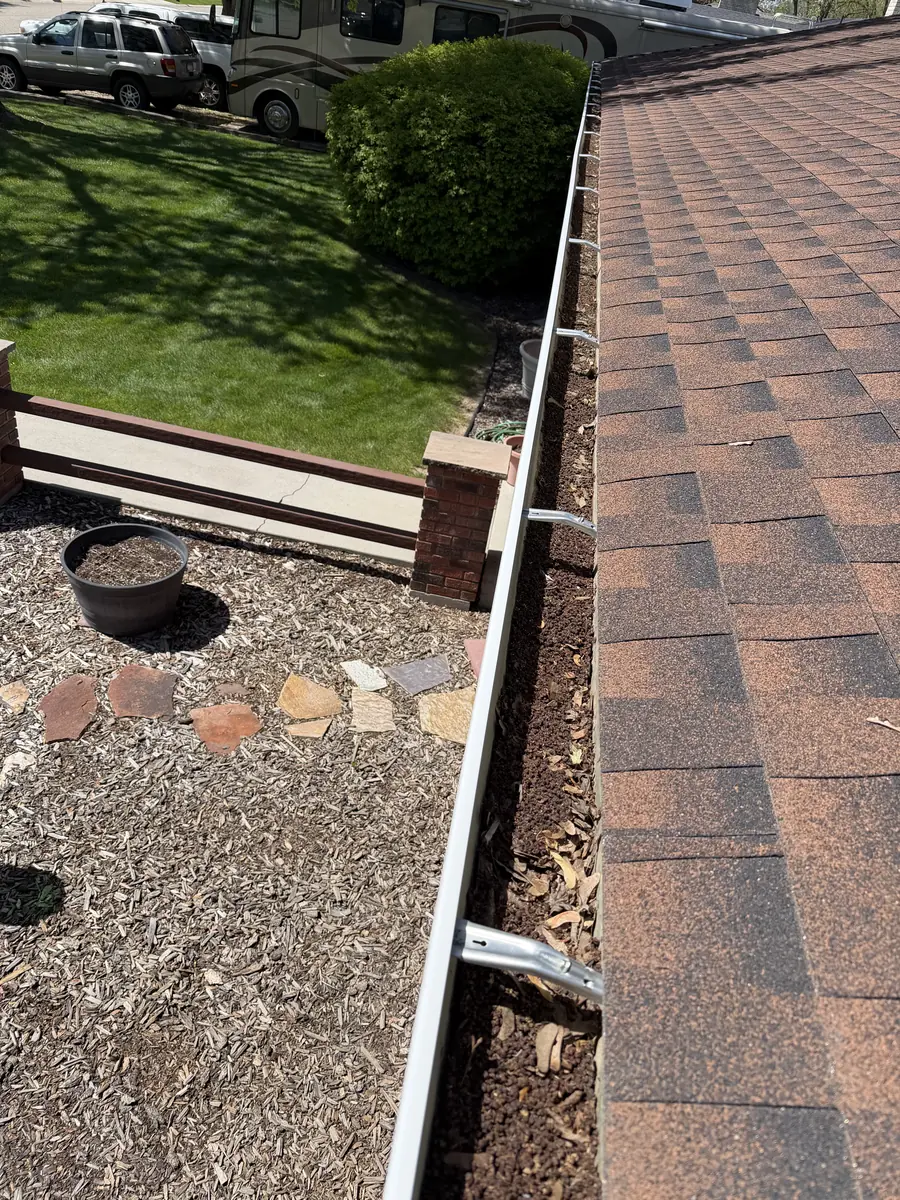 Gutters and roofline on a Boise home with leaves and debris before cleaning