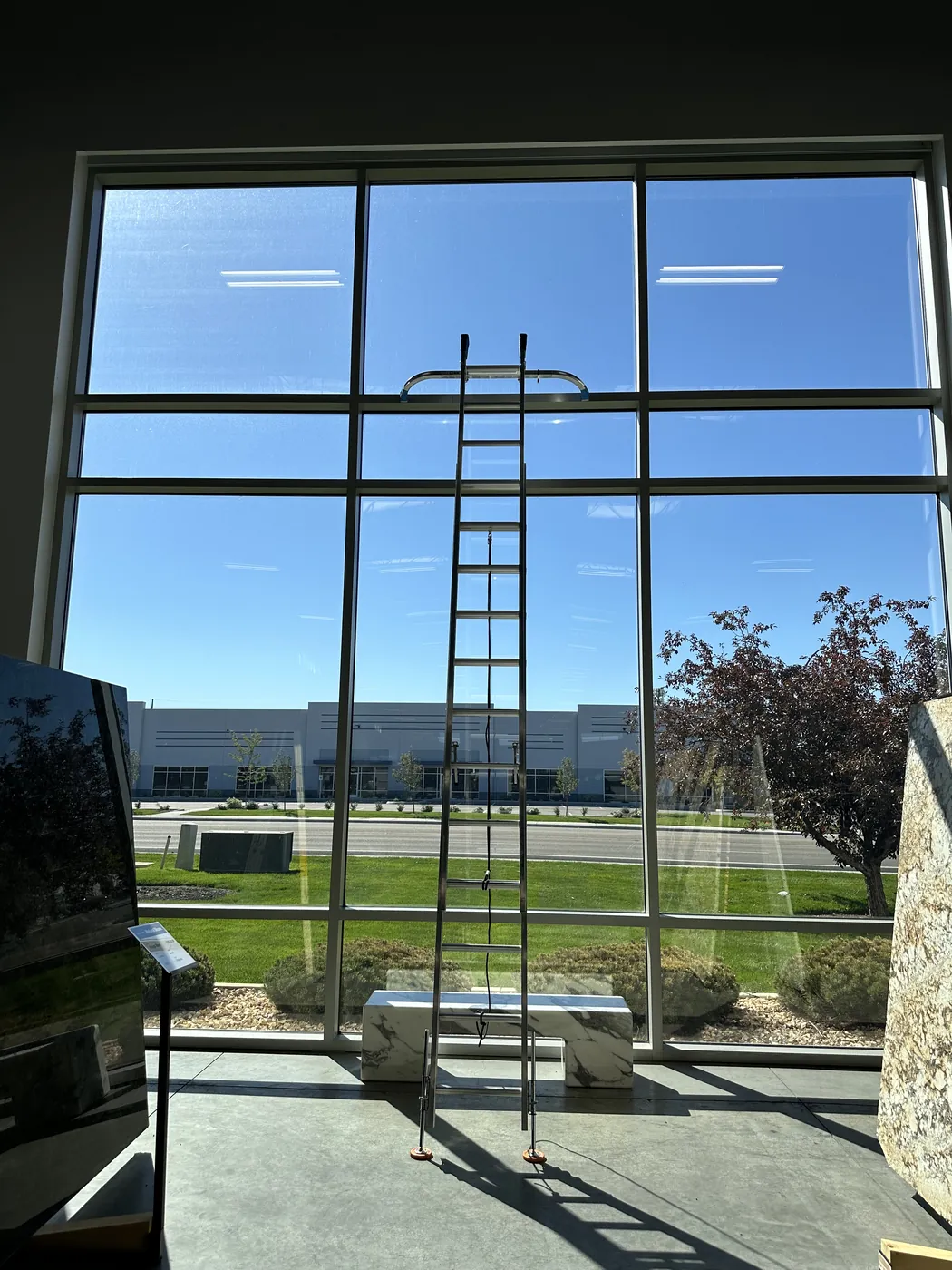 Cleaning tall interior windows from a ladder in a bright Treasure Valley home